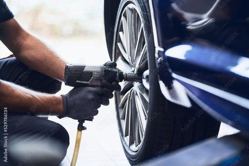 Foto-Duschvorhang nach Maß - Closeup of car mechanic changing car wheel tire with pneumatic wrench in auto service (von baranq)