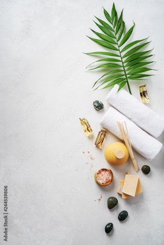 Plissee mit Motiv - Flat lay spa composition with palm tropical leaf, towels, aroma fragrance bottle, handmade organic soaps, oil frangipani, sandal wood, patchouli, pink salt on light concrete surface with copy space. (von PINKASEVICH)